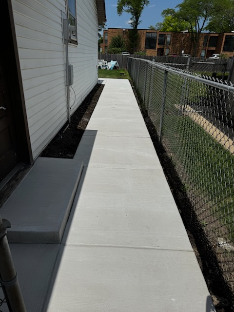 Narrow concrete walkway along a home
