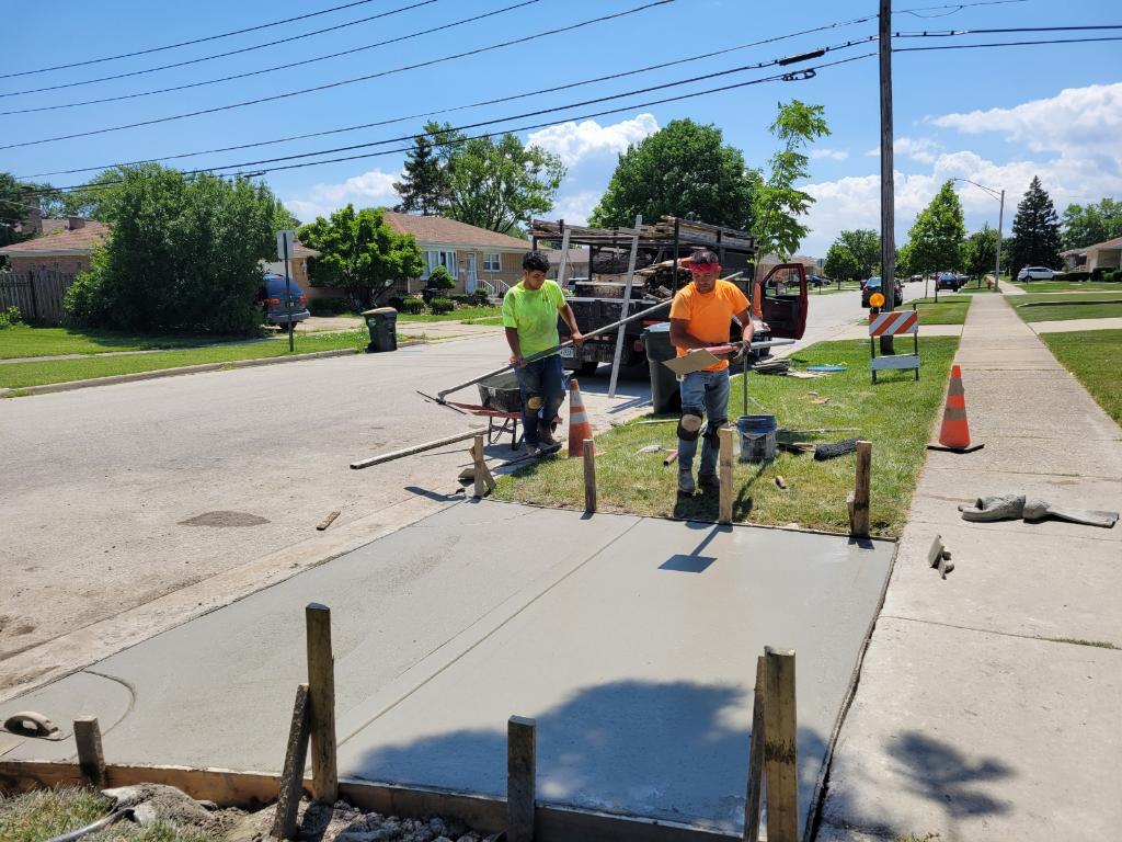 Concrete crew finishing a driveway apron